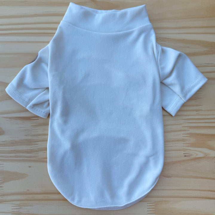 Beige dog sweater on a wooden surface