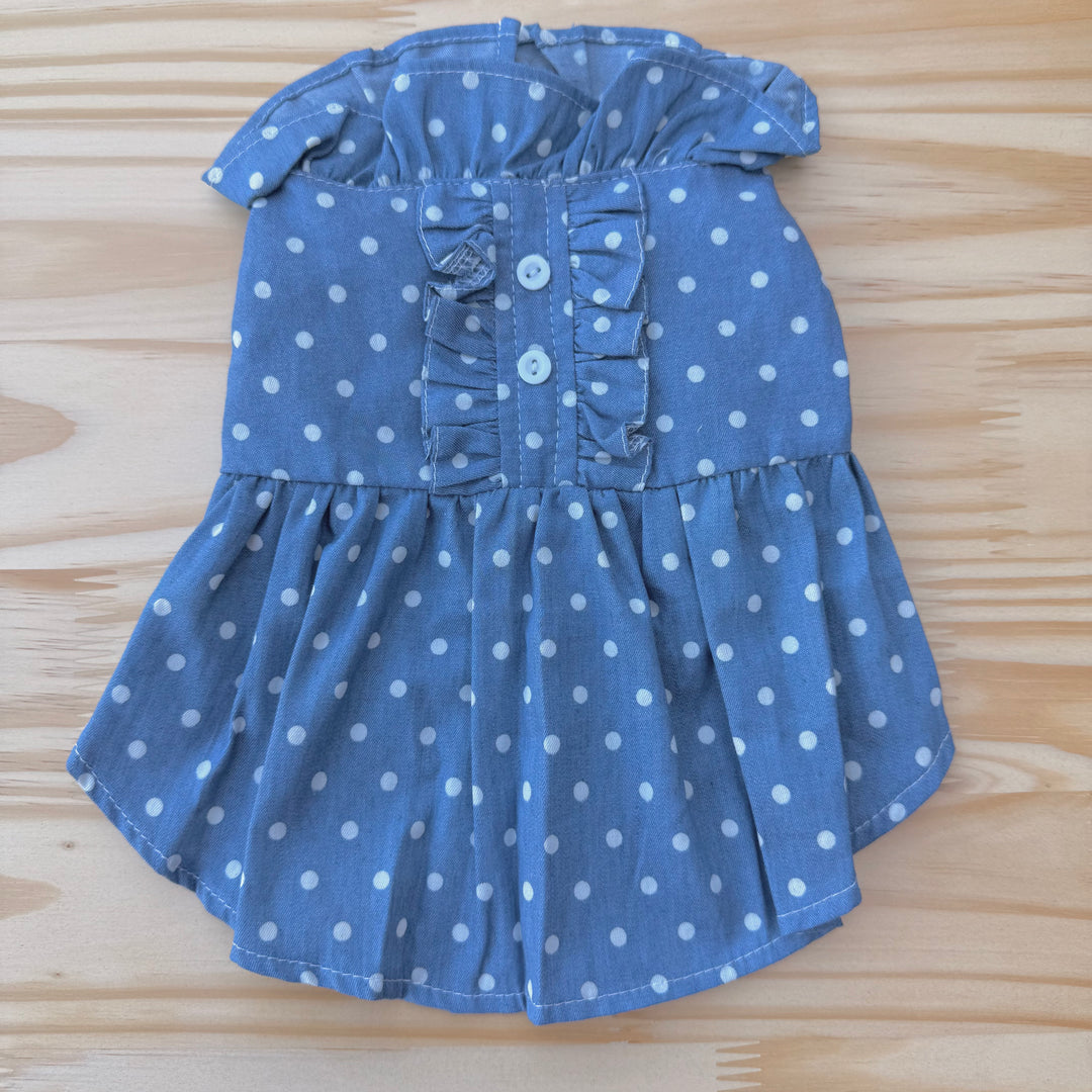 Blue polka dot dog dress on a wooden surface