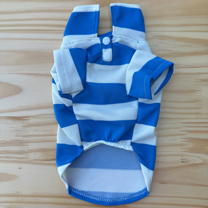 Blue and white striped dog shirt on a wooden surface